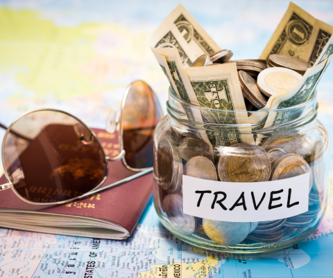 Map, passport, sunglasses, and a jar labeled Travel with money inside