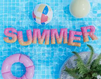 a pool with a pool float, inflatable toys, and the word summer by Warren Umoh courtesy of Unsplash.